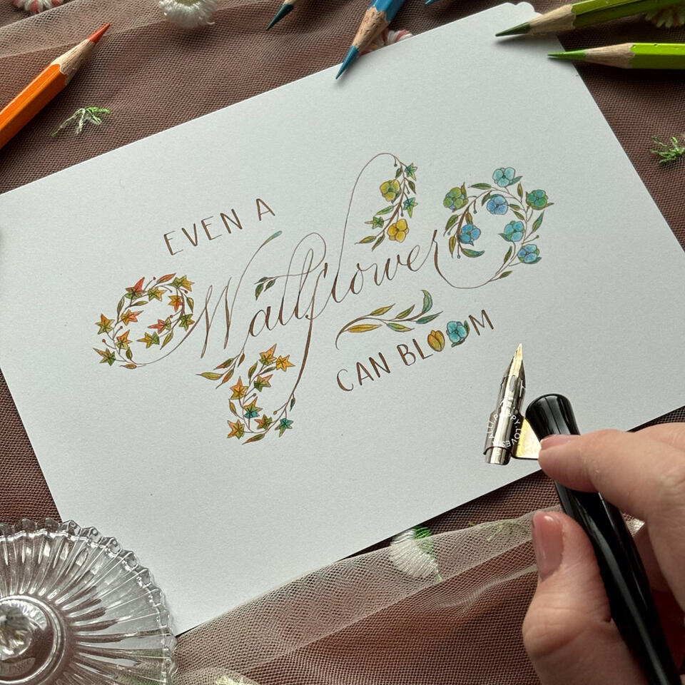 ชิ้นงาน "A Wallflower Can Bloom" โดย Poppy.Loves.Calli เป็นชิ้นงาน Calligraphy เขียนมือด้วยหมึกวอลนัทและตกแต่งดอกไม้ด้วยการระบายสีไม้
